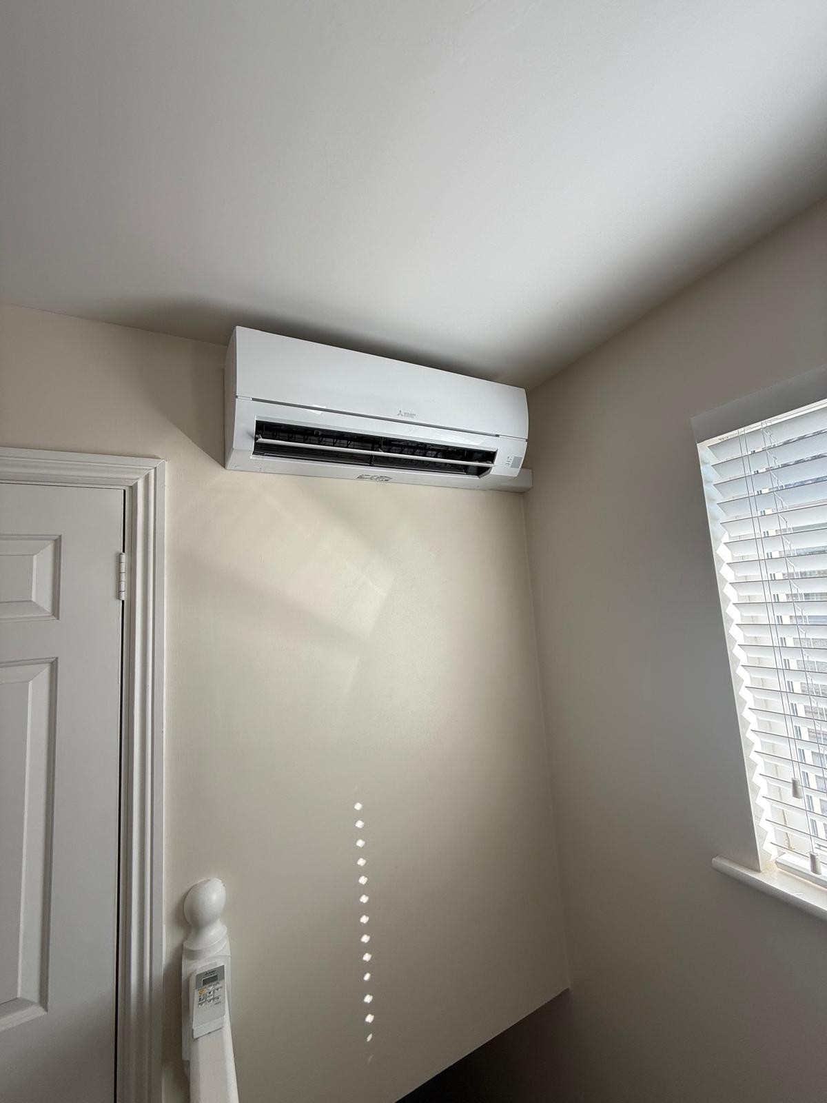 Mitsubishi wall-mounted air conditioning unit installed in a bright home